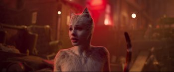 Movie still from “Cats” (2019), directed by Tom Hooper – A woman in a cat costume standing next to a building; Close Up shot, Over the shoulder angle