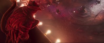 Movie still from “Cats” (2019), directed by Tom Hooper – A person standing on a stage with lights in the background; Close Up shot, Overhead angle