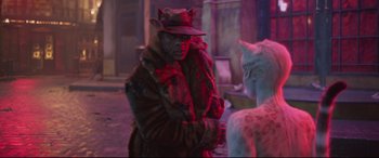Movie still from “Cats” (2019), directed by Tom Hooper – A man dressed as a cat with a hat and a fur coat; Medium shot, Over the shoulder angle