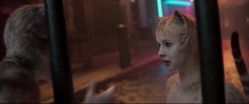 Movie still from “Cats” (2019), directed by Tom Hooper – A woman with a cat's head on a street; Close Up shot, Over the shoulder angle