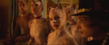 Movie still from “Cats” (2019), directed by Tom Hooper – A group of cats that are standing next to each other; Close Up shot, Over the shoulder angle