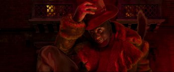 Movie still from “Cats” (2019), directed by Tom Hooper – A man wearing a red coat and a red hat; Medium shot, Low angle