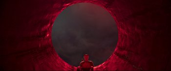 Movie still from “Cats” (2019), directed by Tom Hooper – A person sitting in the middle of a red tunnel; Extreme Wide shot, High angle