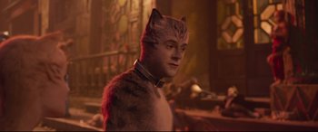 Movie still from “Cats” (2019), directed by Tom Hooper – A man in a cat costume standing next to a window; Close Up shot, Over the shoulder angle