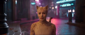 Movie still from “Cats” (2019), directed by Tom Hooper – A woman in a cat costume standing on a city street at night; Close Up shot, High angle