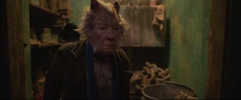 Movie still from “Cats” (2019), directed by Tom Hooper – An old man with a cat's face in a kitchen; Close Up shot, Over the shoulder angle