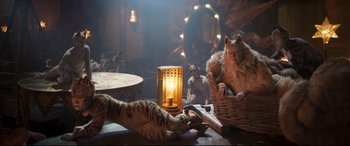 Movie still from “Cats” (2019), directed by Tom Hooper – Two cats are playing with each other on a table; Wide shot, High angle
