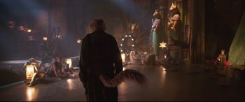 Movie still from “Cats” (2019), directed by Tom Hooper – A man in a robe with a long tail in front of a christmas tree; Wide shot, Over the shoulder angle