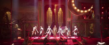 Movie still from “Cats” (2019), directed by Tom Hooper – A group of men standing on top of a stage; Extreme Wide shot, High angle