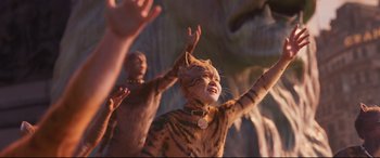 Movie still from “Cats” (2019), directed by Tom Hooper – A group of people with their hands raised; Medium shot, Low angle