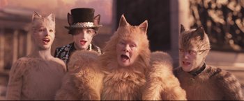 Movie still from “Cats” (2019), directed by Tom Hooper – A woman in a top hat and a cat costume; Close Up shot, Over the shoulder angle