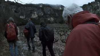 Movie still from “Cave of Forgotten Dreams” (2010), directed by Werner Herzog – A group of people walking through a vineyard; Wide shot, Low angle