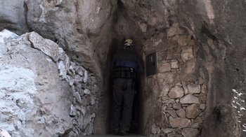 Movie still from “Cave of Forgotten Dreams” (2010), directed by Werner Herzog – A man in a helmet is standing in a cave; Wide shot, Low angle