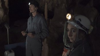 Movie still from “Cave of Forgotten Dreams” (2010), directed by Werner Herzog – A man and a woman wearing headlamps in a cave; Medium shot, Over the shoulder angle