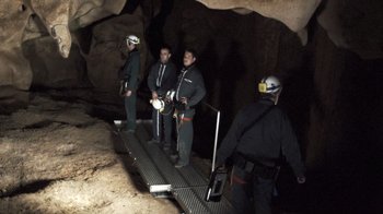 Movie still from “Cave of Forgotten Dreams” (2010), directed by Werner Herzog – A group of people standing in a cave; Wide shot, High angle