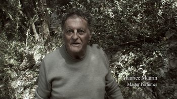 Movie still from “Cave of Forgotten Dreams” (2010), directed by Werner Herzog – An old man in a gray sweater standing in front of a tree; Close Up shot, Low angle