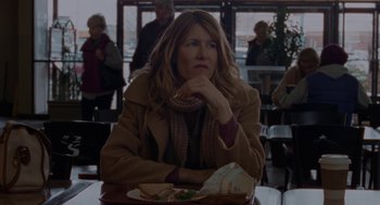 Movie still from “Certain Women” (2016), directed by Kelly Reichardt – A woman sitting at a table with a sandwich in front of her; Medium shot, Over the shoulder angle
