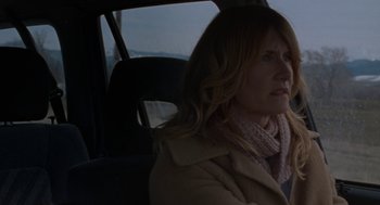 Movie still from “Certain Women” (2016), directed by Kelly Reichardt – A woman sitting in the back seat of a car; Close Up shot, Over the shoulder angle