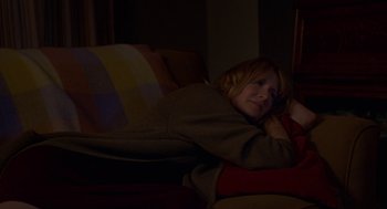 Movie still from “Certain Women” (2016), directed by Kelly Reichardt – A woman laying on a couch in the dark; Medium shot, High angle