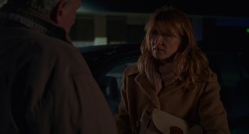 Movie still from “Certain Women” (2016), directed by Kelly Reichardt – A woman in a brown coat is talking to a man in front of a car; Medium shot, Over the shoulder angle