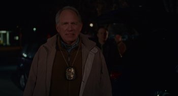 Movie still from “Certain Women” (2016), directed by Kelly Reichardt – An older man wearing a coat with a medal around his neck; Close Up shot, Over the shoulder angle