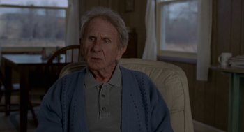 Movie still from “Certain Women” (2016), directed by Kelly Reichardt – An older man sitting in a chair in a room; Close Up shot, Over the shoulder angle