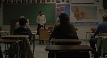 Movie still from “Certain Women” (2016), directed by Kelly Reichardt – A woman standing in front of a classroom full of students; Wide shot, Over the shoulder angle