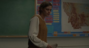 Movie still from “Certain Women” (2016), directed by Kelly Reichardt – A person standing in front of a board holding a knife; Medium shot, Over the shoulder angle
