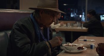 Movie still from “Certain Women” (2016), directed by Kelly Reichardt – An older man sitting at a table with a bowl of food; Medium shot, Over the shoulder angle