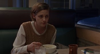 Movie still from “Certain Women” (2016), directed by Kelly Reichardt – A woman sitting at a table with a bowl of food; Medium shot, Over the shoulder angle
