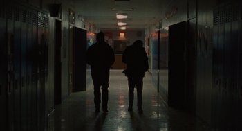 Movie still from “Certain Women” (2016), directed by Kelly Reichardt – Two people are walking down a dark hallway; Wide shot, Low angle