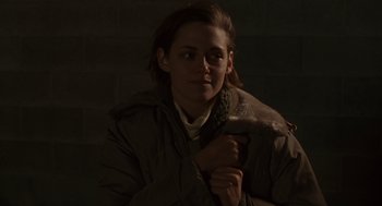 Movie still from “Certain Women” (2016), directed by Kelly Reichardt – A woman in a brown jacket is holding her coat; Close Up shot, High angle