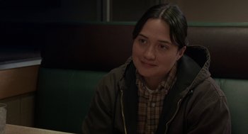 Movie still from “Certain Women” (2016), directed by Kelly Reichardt – A person sitting at a table in a booth; Close Up shot, Over the shoulder angle