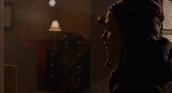 Movie still from “Certain Women” (2016), directed by Kelly Reichardt – A woman looking out of a window in a dark room; Close Up shot, Over the shoulder angle