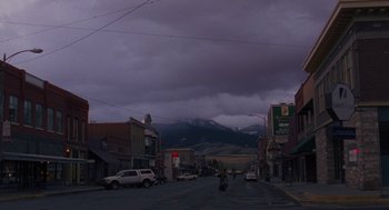 Movie still from “Certain Women” (2016), directed by Kelly Reichardt – A street scene with a person riding a bike; Extreme Wide shot, Low angle