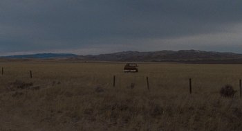 Movie still from “Certain Women” (2016), directed by Kelly Reichardt – A car parked in the middle of an empty field; Extreme Wide shot, High angle