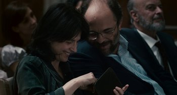 Movie still from “Certified Copy” (2010), directed by Abbas Kiarostami – A man and a woman looking at something on a tablet computer; Close Up shot, Over the shoulder angle