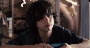 Movie still from “Certified Copy” (2010), directed by Abbas Kiarostami – A young man holding a video game remote control; Close Up shot, Over the shoulder angle