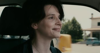 Movie still from “Certified Copy” (2010), directed by Abbas Kiarostami – A person sitting in a car; Close Up shot, Over the shoulder angle