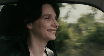 Movie still from “Certified Copy” (2010), directed by Abbas Kiarostami – A woman is looking out the window of a car; Close Up shot, Over the shoulder angle