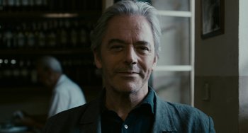 Movie still from “Certified Copy” (2010), directed by Abbas Kiarostami – A person wearing a jacket; Close Up shot, Over the shoulder angle