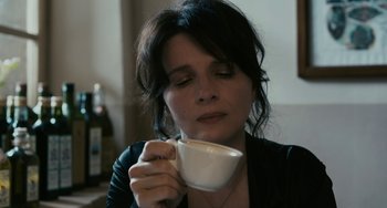 Movie still from “Certified Copy” (2010), directed by Abbas Kiarostami – A woman is holding a coffee cup in her hands; Close Up shot, High angle