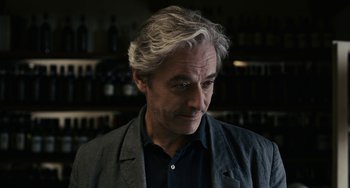 Movie still from “Certified Copy” (2010), directed by Abbas Kiarostami – A person wearing a jacket; Close Up shot, Low angle