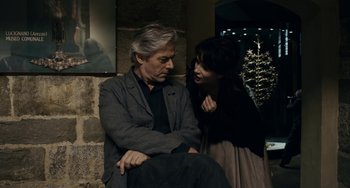 Movie still from “Certified Copy” (2010), directed by Abbas Kiarostami – An older man and a young woman are sitting together; Medium shot, Over the shoulder angle