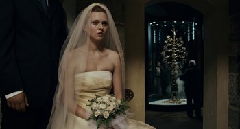 Movie still from “Certified Copy” (2010), directed by Abbas Kiarostami – A woman in a wedding dress holding a bouquet of flowers; Medium shot, Over the shoulder angle