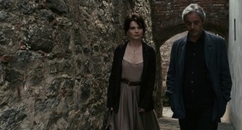 Movie still from “Certified Copy” (2010), directed by Abbas Kiarostami – A woman standing next to a man in a black jacket; Medium shot, Over the shoulder angle