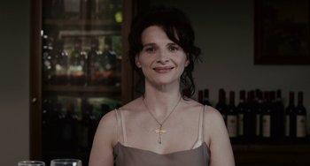 Movie still from “Certified Copy” (2010), directed by Abbas Kiarostami – A woman wearing a dress and a necklace; Close Up shot, Over the shoulder angle