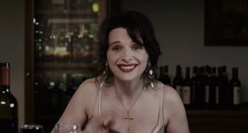 Movie still from “Certified Copy” (2010), directed by Abbas Kiarostami – A woman sitting at a table with a glass of wine in front of her; Close Up shot, Over the shoulder angle