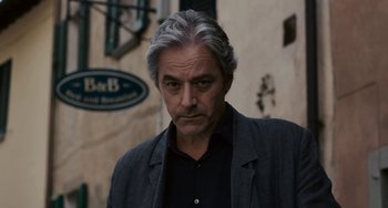 Movie still from “Certified Copy” (2010), directed by Abbas Kiarostami – A person wearing a jacket; Close Up shot, Low angle