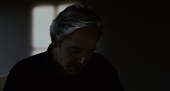 Movie still from “Certified Copy” (2010), directed by Abbas Kiarostami – A person in a dark room; Close Up shot, Low angle